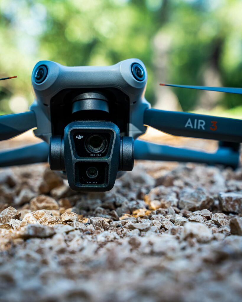 Detailed view of a drone on rough gravel, set in a lush outdoor scene.